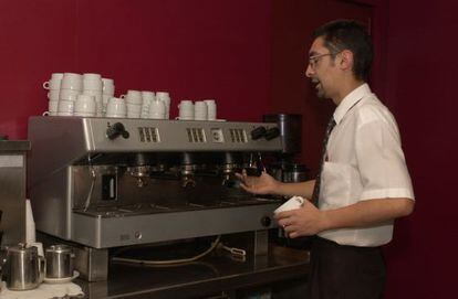 Un camarero se dispone a preparar un caf&eacute; en una cafetera industrial.