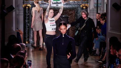 Una activista exhibe una pancarta durante el desfile de Victoria Beckham en la Semana de la Moda de París