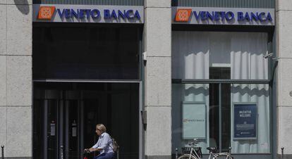 Una mujer pasa delante de una oficina de Veneto Banca en Mil&aacute;n