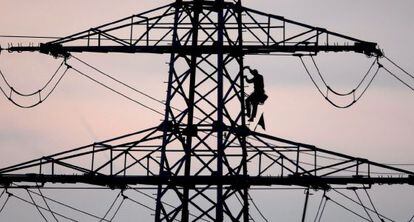 Un operario baja de una torre de luz.