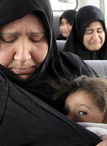 Refugiadas chiíes lloran al llegar en autobús al barrio Ciudad Sadr de Bagdad.