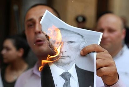 Un manifestante quema una foto de Putin.