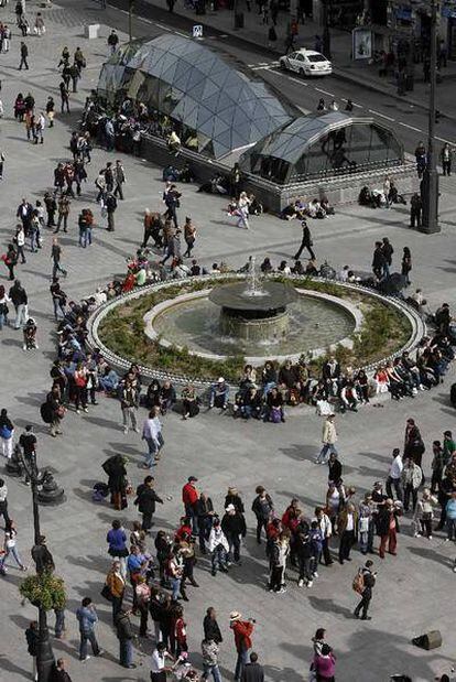 Entorno de la Puerta del Sol donde los visitantes tienen que sentarse en el suelo por la ausencia de bancos.