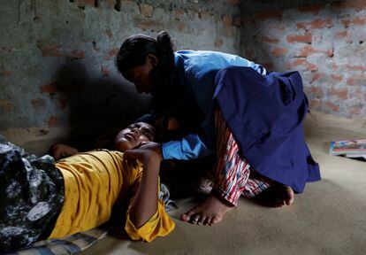 Parwati Sunar checks on her eldest son, 11, who has a fever. 