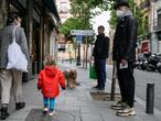 Una mujer camina junto a su hijo este martes por una calle de Madrid.