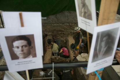 Trabajos de exhumación en el cementerio de Colmenar Viejo. En los carteles, fotografías de algunas de las víctimas.