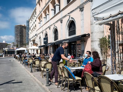 Un camarero atiende a una pareja en una terraza de Palamós (Girona).