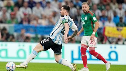 Lionel Messi juega el balón ante Héctor Herrera.