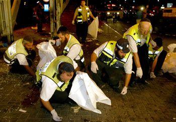 Un grupo de religiosos judíos busca y recoge restos humanos desperdigados por el atentado de anoche en Jerusalén.