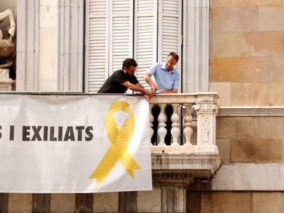 Dos trabajadores comienzan a retirar la pancarta del Palau de la Generalitat. En vídeo, el momento en el que dos funcionarios de la Generalitat retiran la pancarta este viernes.