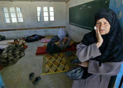 Una mujer palestina, a las puertas de una escuela de la ONU donde su familia ha encontrado refugio tras ser destruida su casa.