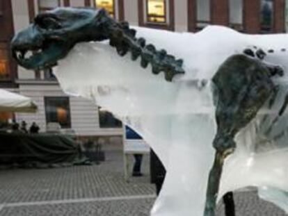 Un niño toca una escultura de hielo de un oso polar que se derrite para revelar un esqueleto de bronce en Copenhague el 8 de diciembre de 2009