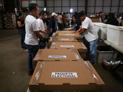 Trabajadores electorales sellan cajas con formularios antes de las elecciones presidenciales, en San Marcos, El Salvador.