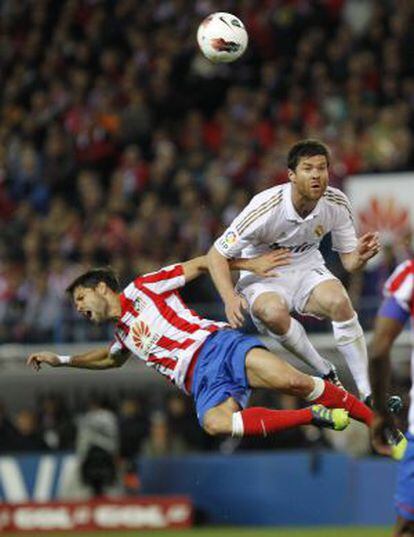 Xabi Alonsoa salta por el balón con el brasileño Diego