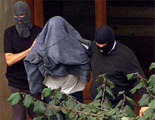 Dos <i>ertzainas</i> llevan prendido a uno de los miembros del <b></b><i>comando Buruntza</i> detenido en Guipúzcoa.