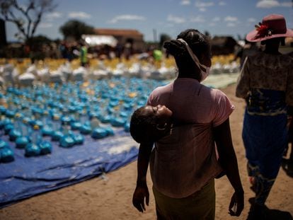 Una mujer con bebé a la espalda en una distribución de ayuda del Programa Mundial de Alimentos en Antanimora, Madagascar, en febrero de 2022.