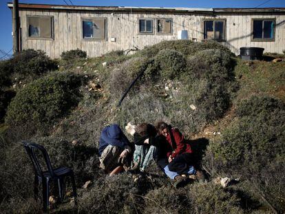 Mujeres israelíes sentadas cerca de una vivienda durante el segundo día del desalojo de los asentamientos de Amona.