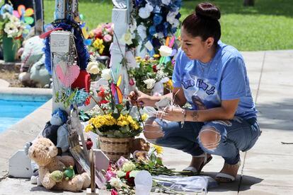 Cynthia Flores, madre de José Flores, limpia las cruces del memorial de su hijo en el centro de Uvalde.