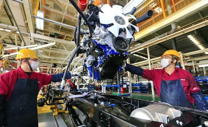 Trabajadores en una planta de vehículos a motor. / EFE