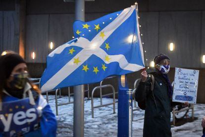 Un manifestante ondea frente al Parlamento Escocés una bandera con una mezcla de la escocesa y de la de la UE, la noche del 31 de diciembre.