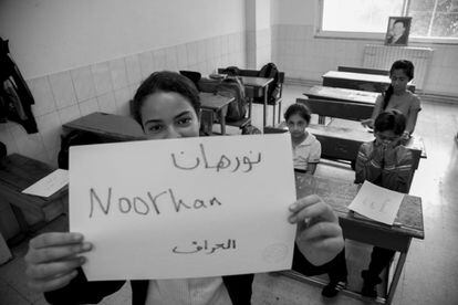Varios alumnos iraquíes del colegio en uno de los aulas. La joven Noorhan muestra su nombre junto al de Irak en árabe.
