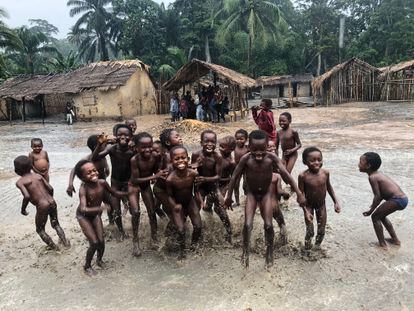 Los niños de una comunidad forestal remota juegan bajo la lluvia en el norte de la RDC. Sus aldeas tienen derechos de tenencia sobre los bosques, pero lamentan que, a menudo, su  futuro se sella a 2.000 kilómetros, en las oficinas de altos cargos en Kinshasa.