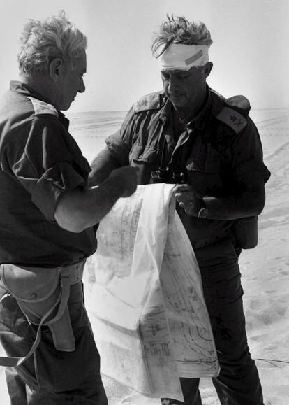 Fotografía cedida por la oficina de prensa del Gobierno israelí del entonces general de brigada Ariel Sharon (d) con la cabeza vendada después de resultar herido, estudiando los mapas con el jefe del Estado Mayor Haim Bar-Lev durante la guerra de Yom Kippur en 1973 en algún lugar del Desierto del Sinaí en Egipto.