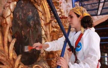 Conservadores limpiando uno de los retablos de Santa Prisca