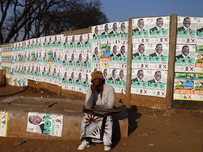 Una mujer posa junto a las imágenes de candidatos en el barrio de Mbare, en Harare, el 21 de agosto.