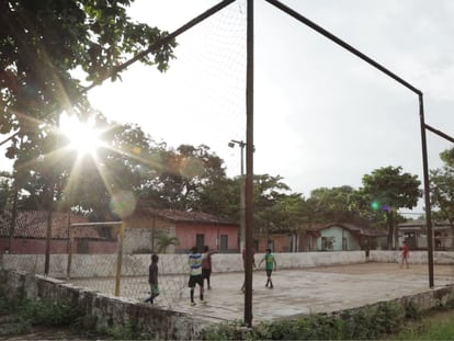 Un grupo de niños juegan fútbol en la cancha de la comunidad siderúrgica de Piquiá (Brasil), en 2021.