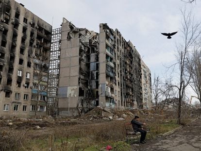 A local resident sits in front of apartment blocks destroyed in the course of Russia-Ukraine conflict in Mariupol, Russian-controlled Ukraine, February 5, 2023. REUTERS/Alexander Ermochenko