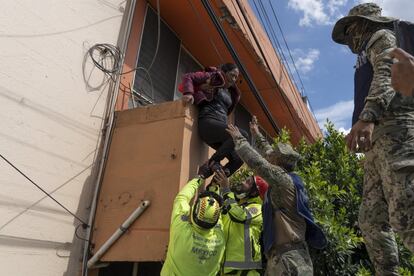 Una mujer es auxiliada por miembros de la Secretaría de Marina para dejar su domicilio en la zona centro de Tula, Hidalgo, debido a la orden de evacuación.