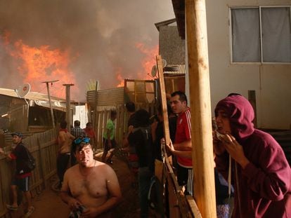 Al menos 6.000 personas han sido evacuadas a causa de un incendio registrado en los alrededores de la localidad chilena de Viña del Mar, en la región de Valparaíso (Chile). En la imagen, algunos residentes de Viña del Mar trabajan para evitar que el fuego se extienda a sus casas.