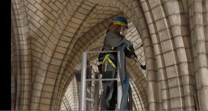This video grab taken on April 13, 2022, from AFP footage shows a staff member use a vacuum cleaner inside Notre-Dame de Paris, after the blaze that made the spire collapsed and destroyed much of the roof on April 15, 2019. - Three years after the devastating fire, Notre-Dame cathedral in Paris is mostly cleared of a thick layer of soot as an army of craftsmen race to meet a deadline to reopen in time for the 2024 Olympics. (Photo by Colin BERTIER / AFP)