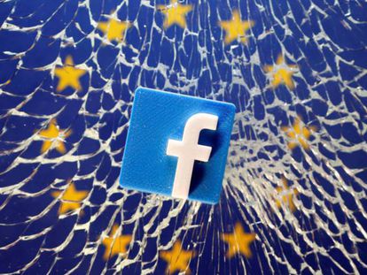 Un logo de Facebook en un cristal roto con la bandera europea en el fondo.
