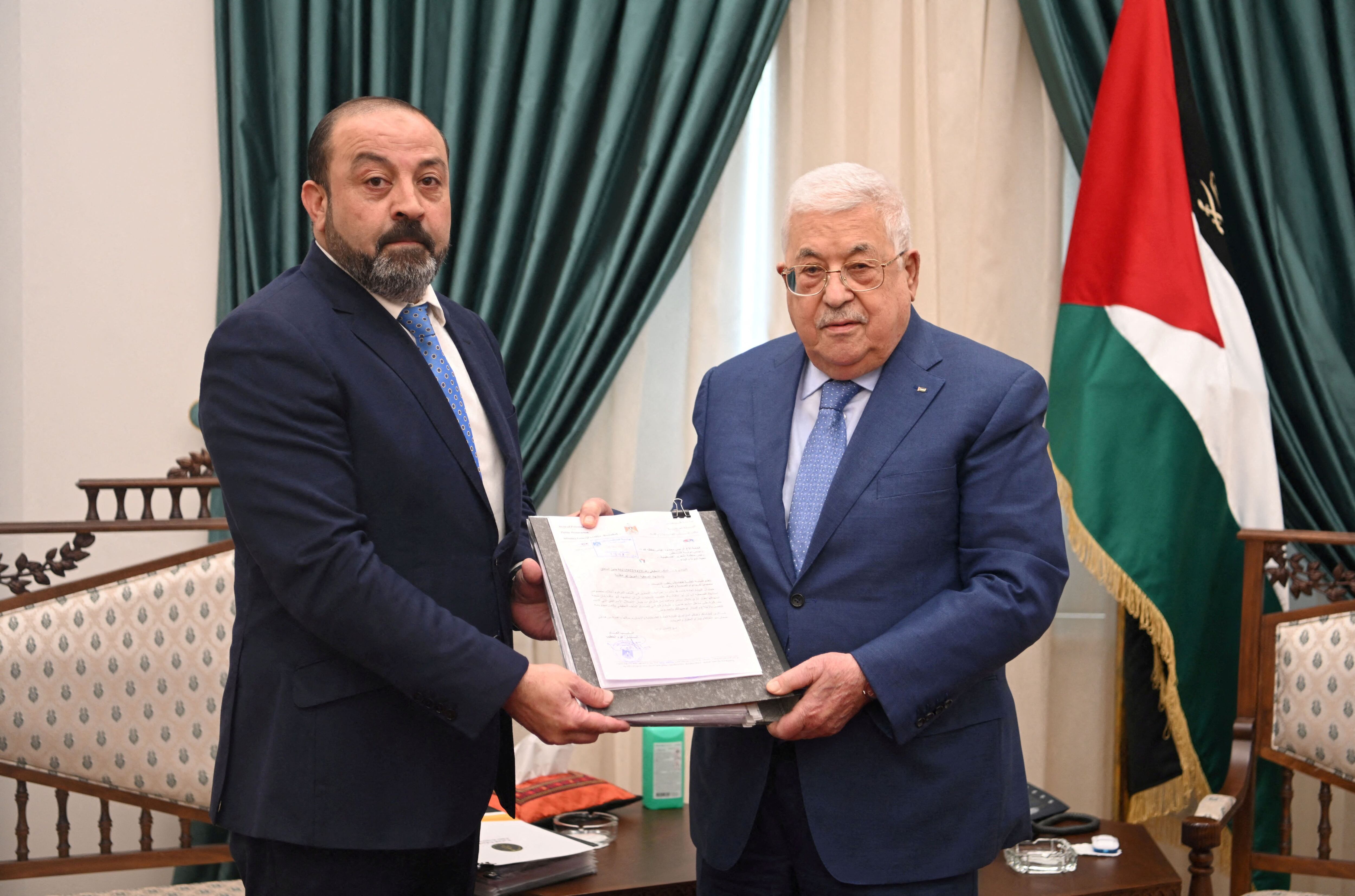 El fiscal general palestino, Akram al Jatib, entrega el informe de la autopsia de Shireen Abu Akleh al presidente palestino, Mahmud Abbas (derecha), el jueves en Ramala.
