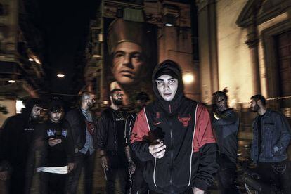 Un grupo de jóvenes del barrio de Forcella, reunido en la noche napolitana bajo el mural con la imagen de san Gennaro, obra del artista Jorit.