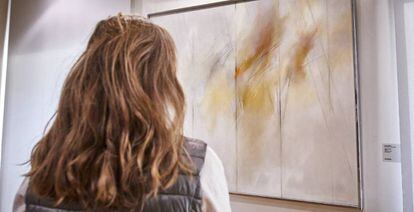 Una mujer observa una de las obras de la exposición Zóbel y el arte español de posguerra, en Madrid.