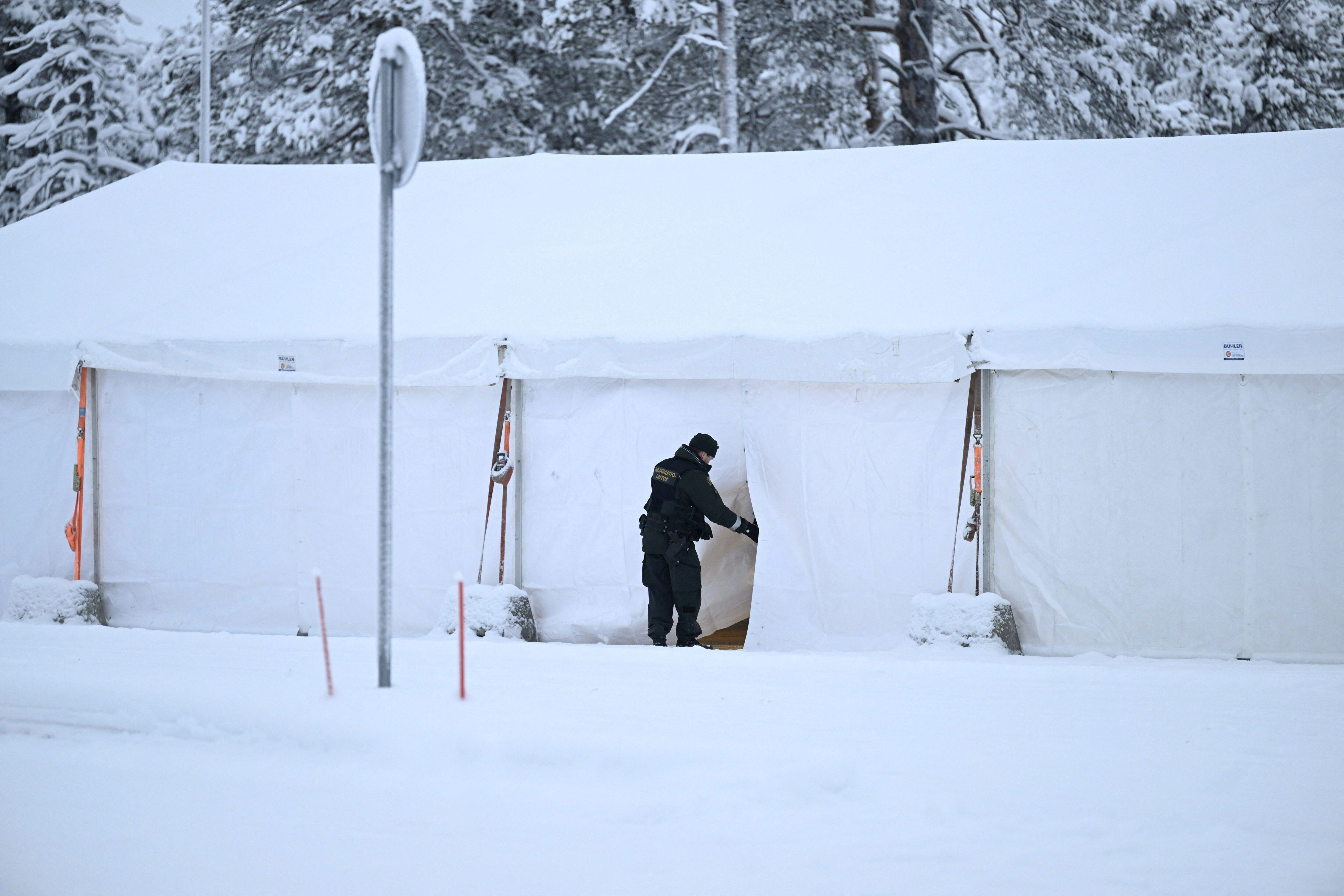 Un guardia fronterizo finlandés inspeccionaba una tienda de campaña habilitada para la llegada de migrantes, este martes en el cruce fronterizo de Raja-Jooseppi.