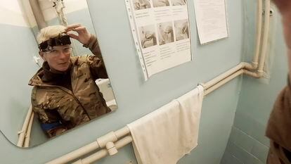 Yuliia Paievska, known as Taira, looks in the mirror and turns off her camera in Mariupol, Ukraine on Feb. 27, 2022. Using a body camera, she recorded her team's frantic efforts to bring people back from the brink of death. (Yuliia Paievska via AP)