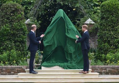 Guillermo y Enrique comienzan a retirar la lona que cubría la estatua de su madre, la princesa Diana, en el jardín del palacio de Kensington, en su primer acto público donde aparecen juntos desde el funeral de su abuelo, el duque de Edimburgo.