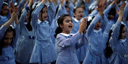 Palestinian schoolgirls participate in the morning exercise at an UNRWA-run school, on the first day of a new school year, in Gaza City