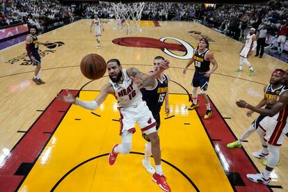 El alero del Miami Heat, Caleb Martin, pierde el control del balón cuando se dirige a la canasta contra  Nikola Jokic, de los Denver Nuggets, durante la primera mitad del Juego 4 de las Finales de la NBA.