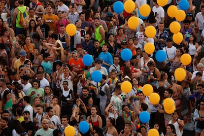 Decenas de personas miran unos globos lanzados al aire durante la marcha del Orgullo Gay.