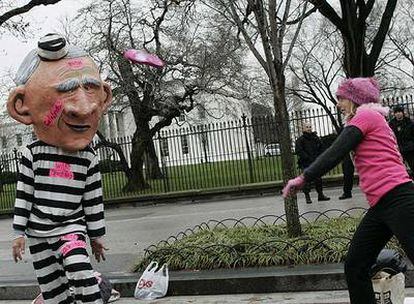 Una manifestante lanza un zapato a un compañero disfrazado de Bush, frente a la Casa Blanca