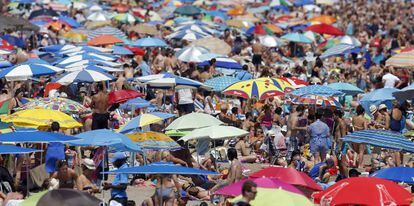 Un gran n&uacute;mero de personas disfrutan del buen tiempo estival en la playa de la Malvarrosa, en Valencia. 