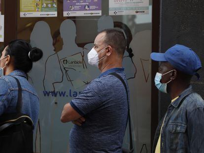 Vecinos de Bilbao, protegidos con mascarillas mientras esperan ser atendidos en una oficina pública.