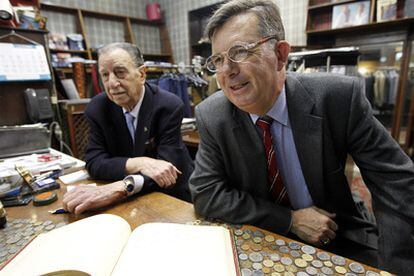 Fernando Pérez de Santa María, padre e hijo, en el mostrador de Samaral con el libro de firmas de sus clientes más ilustres.