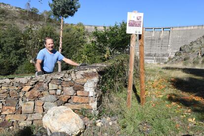 Un vecino de Villagatón trabaja en su huerta, a pocos metros del muro del embalse.