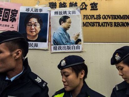 Policías junto a carteles de dos desaparecidos, el domingo en Hong Kong.